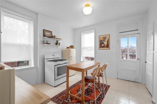 kitchen featuring white range with gas stovetop and plenty of natural light