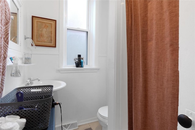 bathroom featuring tile patterned flooring, toilet, and sink