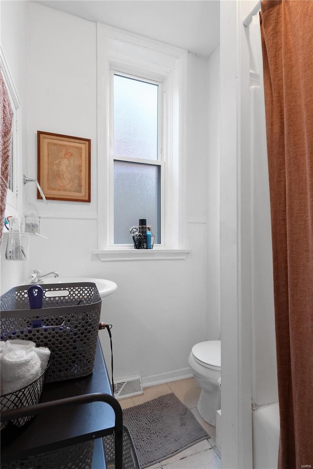 bathroom with tile patterned flooring and toilet