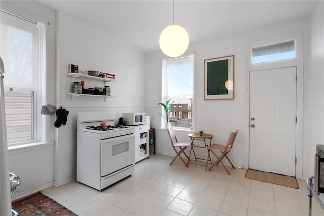 kitchen featuring plenty of natural light, hanging light fixtures, and white appliances