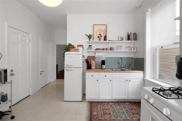 kitchen featuring decorative backsplash, wooden counters, white appliances, sink, and white cabinets