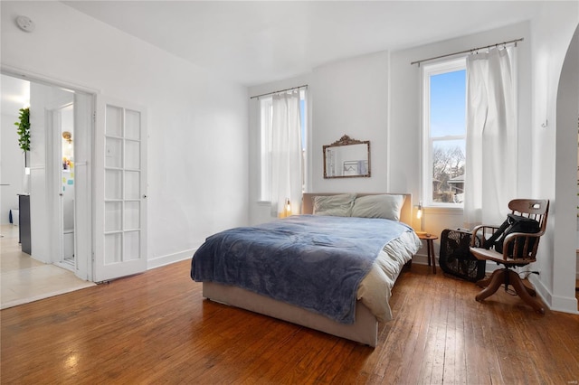 bedroom with wood-type flooring and multiple windows