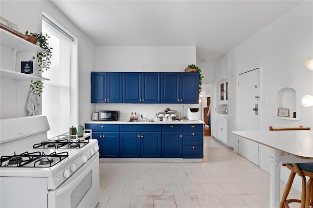 kitchen featuring blue cabinets, sink, and white range with gas cooktop