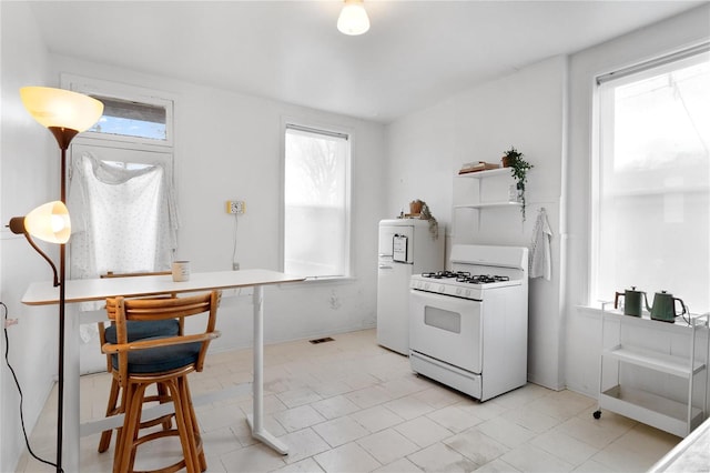 kitchen with plenty of natural light, refrigerator, and white range with gas stovetop