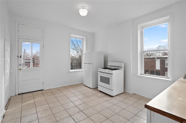 kitchen featuring white appliances and light tile patterned flooring