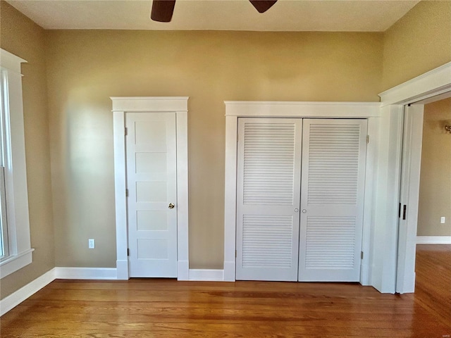 unfurnished bedroom featuring a closet, hardwood / wood-style flooring, and ceiling fan