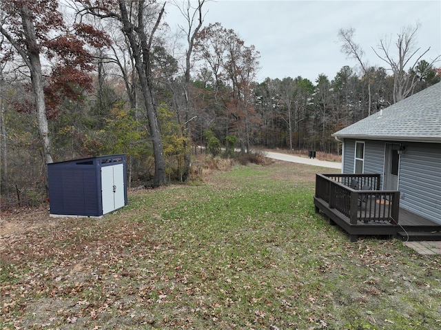 view of yard featuring a storage unit and a wooden deck