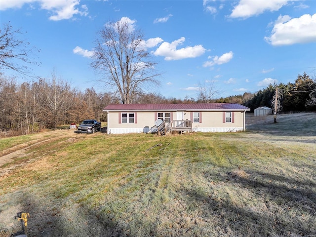 manufactured / mobile home with a front lawn and a storage shed