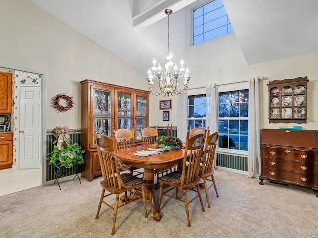 dining room with light carpet, high vaulted ceiling, and an inviting chandelier