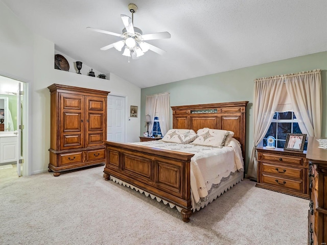 bedroom featuring light colored carpet, vaulted ceiling, ceiling fan, and ensuite bathroom