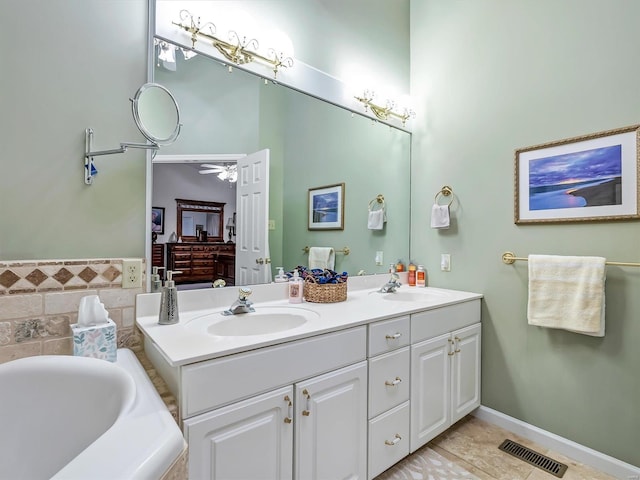 bathroom featuring vanity, a relaxing tiled tub, tile patterned floors, and ceiling fan