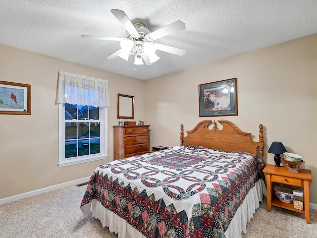 carpeted bedroom featuring ceiling fan and a textured ceiling