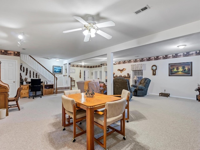 dining space featuring ceiling fan and light colored carpet