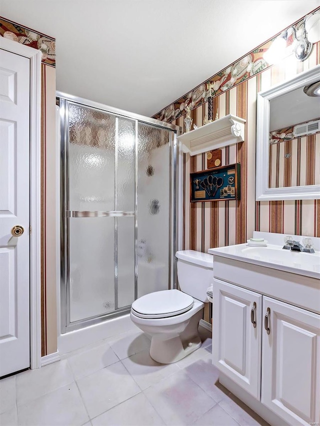 bathroom with tile patterned flooring, vanity, toilet, and a shower with shower door