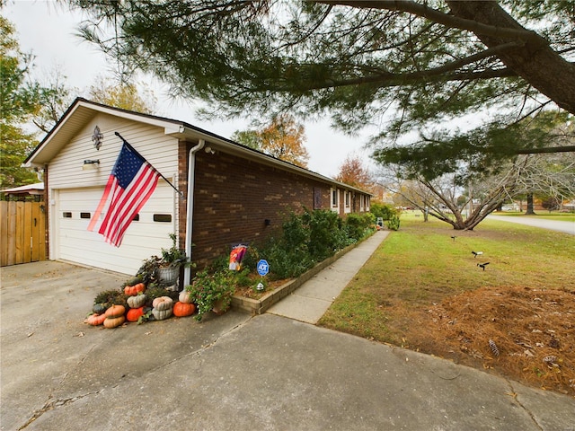 view of side of home featuring a yard and a garage