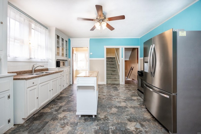 kitchen featuring ceiling fan, sink, white cabinets, and appliances with stainless steel finishes