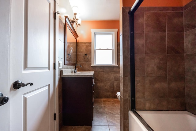 full bathroom featuring tile patterned floors, vanity, shower / washtub combination, tile walls, and toilet