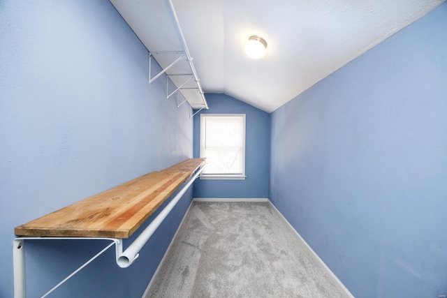 walk in closet featuring carpet flooring and vaulted ceiling