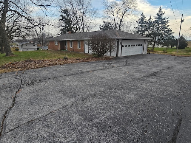 single story home featuring a garage and a front lawn