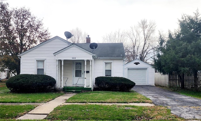 bungalow with a garage, an outdoor structure, and a front yard