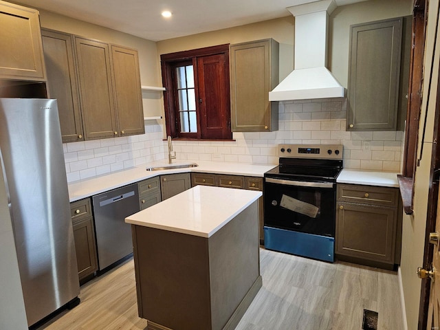 kitchen featuring sink, a kitchen island, light hardwood / wood-style floors, custom range hood, and stainless steel appliances