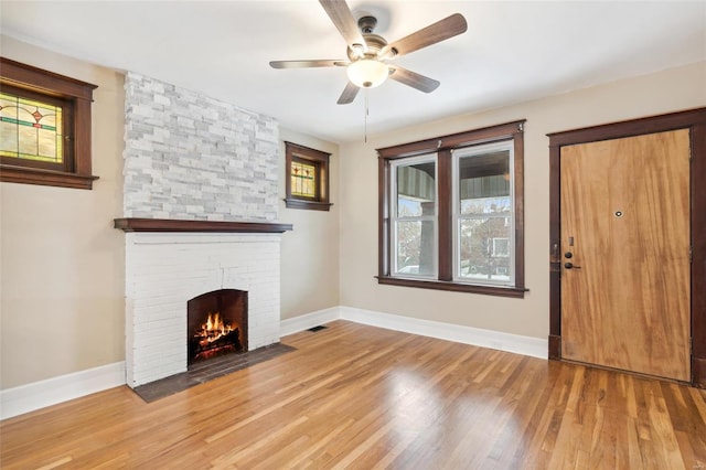 unfurnished living room with a fireplace, ceiling fan, and hardwood / wood-style floors