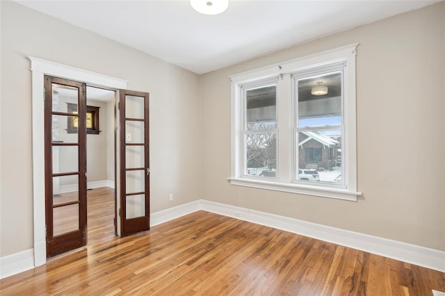 spare room featuring hardwood / wood-style floors and french doors