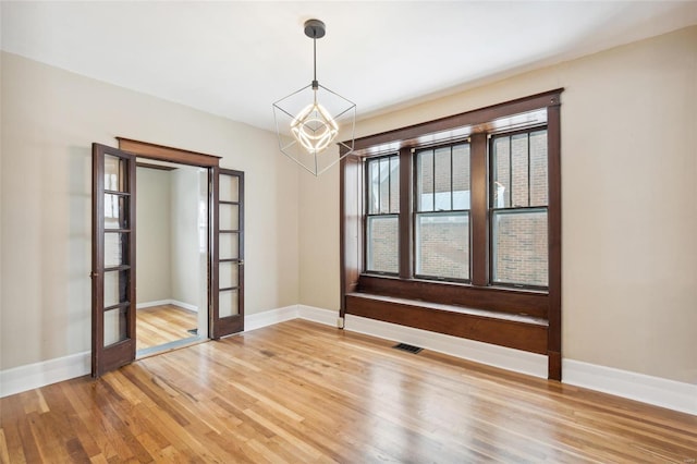 unfurnished room with hardwood / wood-style floors and french doors