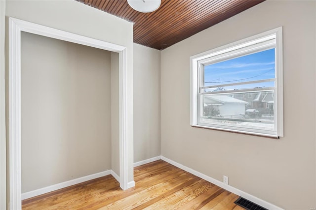 spare room featuring wood ceiling and light hardwood / wood-style flooring