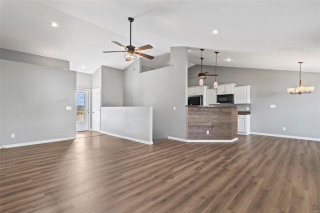 unfurnished living room featuring dark hardwood / wood-style flooring, high vaulted ceiling, and ceiling fan with notable chandelier