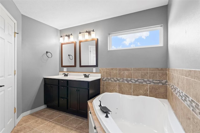 bathroom with tile patterned floors, a bathtub, and vanity