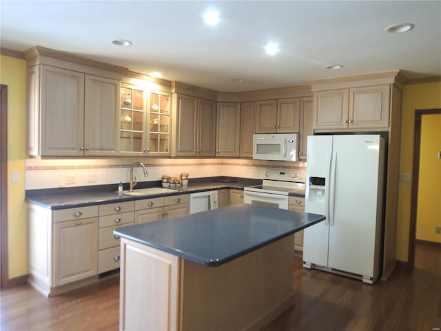 kitchen with dark wood-type flooring, white appliances, sink, and a kitchen island