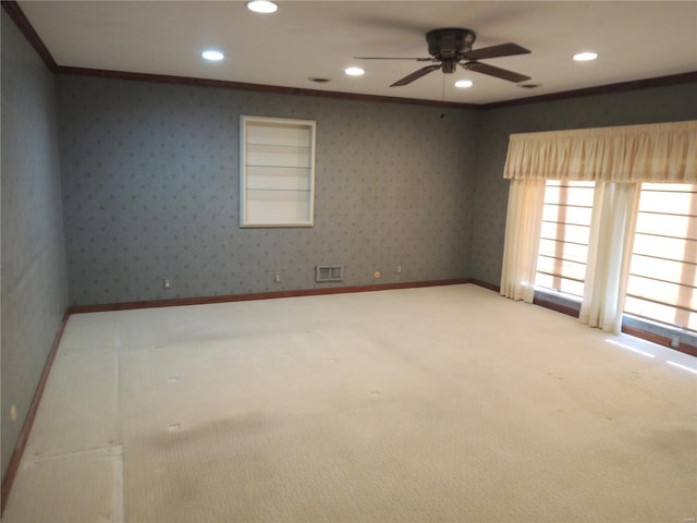 spare room featuring crown molding, ceiling fan, and carpet