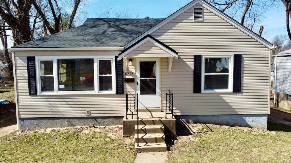 bungalow-style house with a front lawn