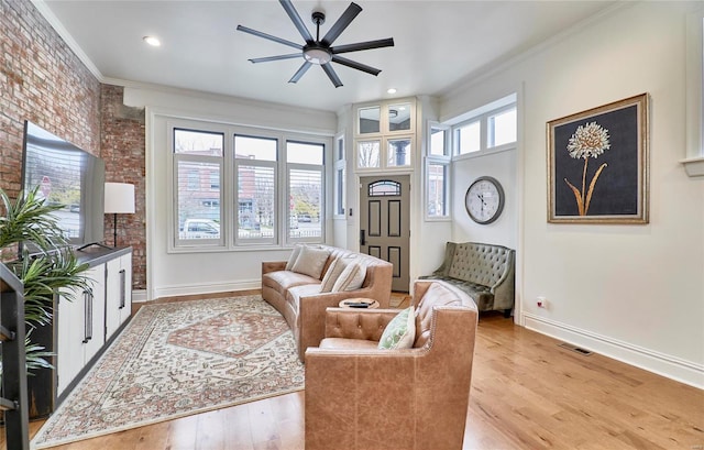 living room with plenty of natural light, light hardwood / wood-style floors, and ornamental molding