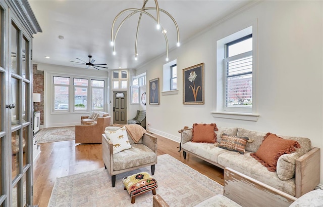 living room featuring ceiling fan, light wood-type flooring, and crown molding