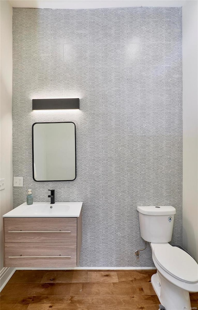 bathroom with vanity, toilet, and wood-type flooring