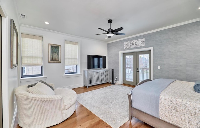 bedroom featuring access to exterior, wood-type flooring, multiple windows, and ceiling fan