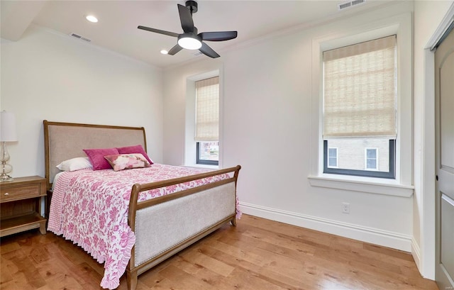 bedroom featuring ceiling fan, a closet, ornamental molding, and light wood-type flooring