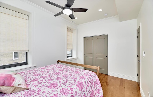 bedroom with a closet, ceiling fan, light hardwood / wood-style flooring, and crown molding