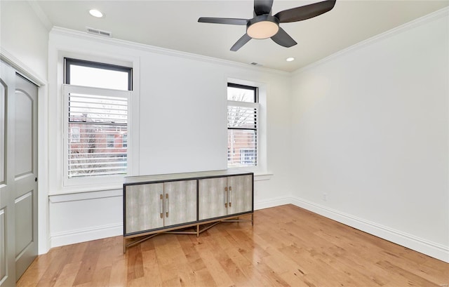 empty room with crown molding, light hardwood / wood-style flooring, and ceiling fan