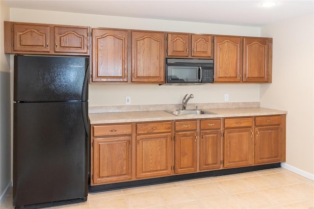 kitchen featuring black appliances, light tile patterned flooring, and sink