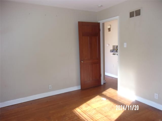 spare room featuring visible vents, baseboards, and wood finished floors