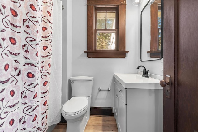 bathroom featuring curtained shower, toilet, vanity, and hardwood / wood-style flooring