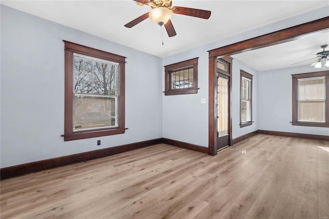 empty room with ceiling fan, plenty of natural light, and light wood-type flooring