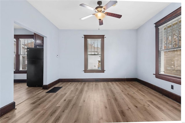 spare room featuring ceiling fan, light hardwood / wood-style floors, and a wealth of natural light