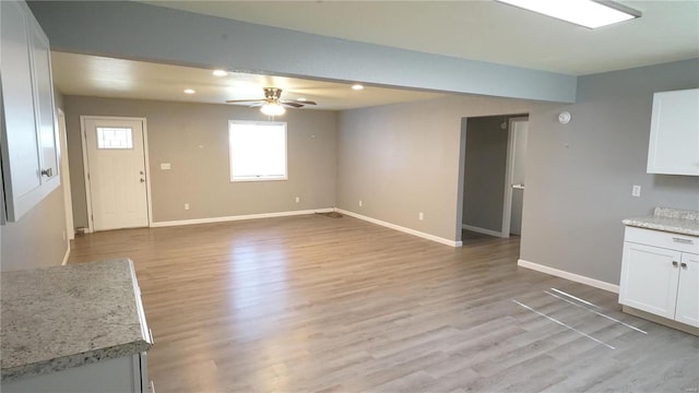 unfurnished living room featuring ceiling fan and light hardwood / wood-style floors