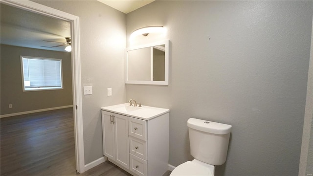 bathroom featuring ceiling fan, hardwood / wood-style floors, vanity, and toilet