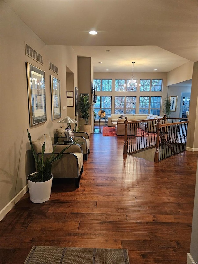 living room with dark hardwood / wood-style floors and a notable chandelier