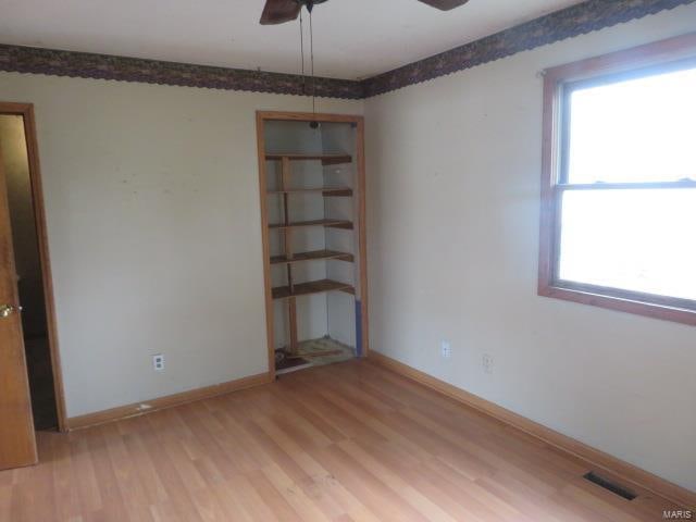 spare room featuring plenty of natural light, light hardwood / wood-style floors, and ceiling fan